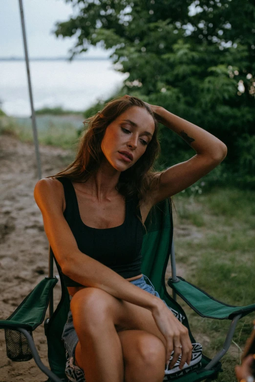 a woman is sitting outside in a lawn chair