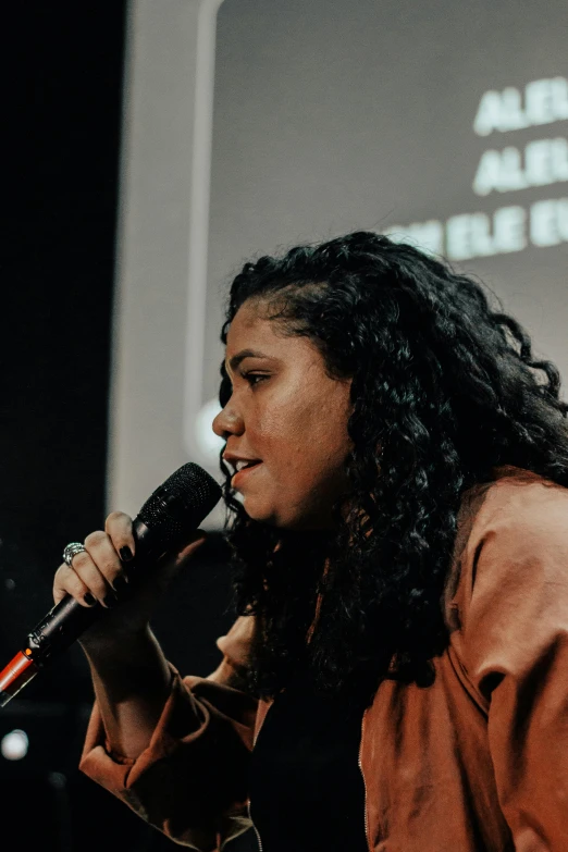 a woman standing on a stage holding a microphone