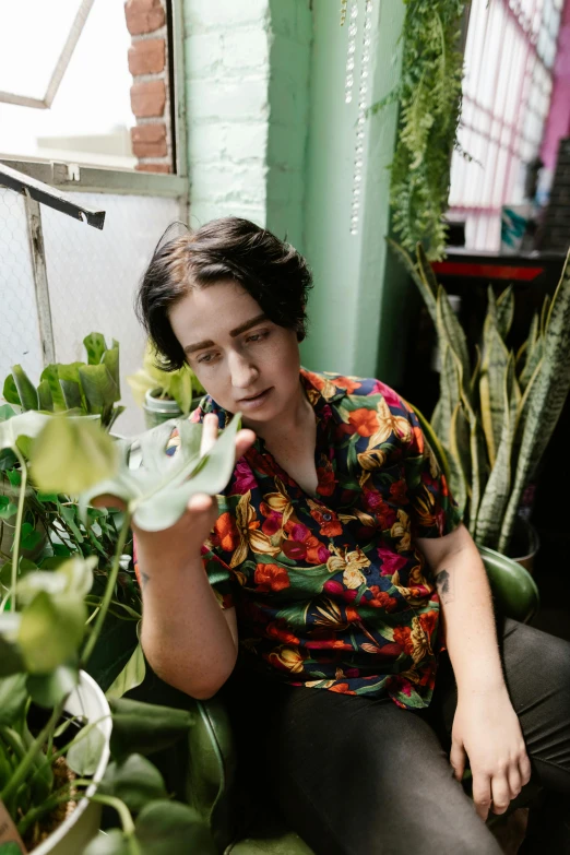 a person sitting on a couch with some plants