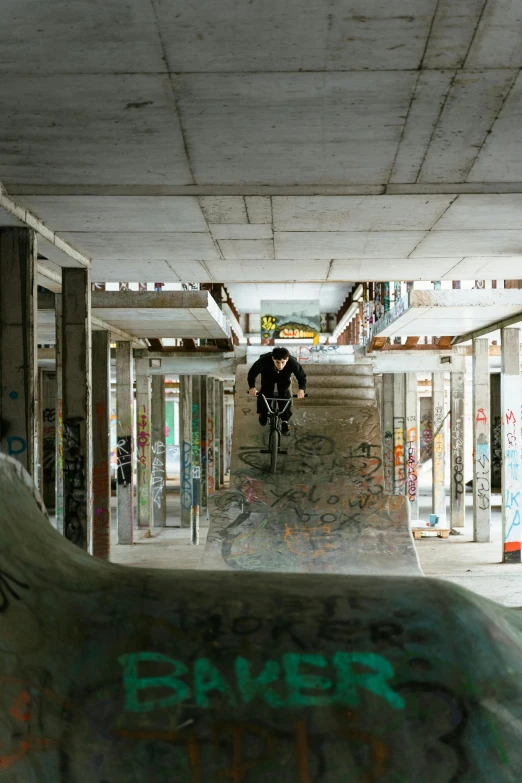 an abandoned skate park has graffiti on the walls and concrete floors