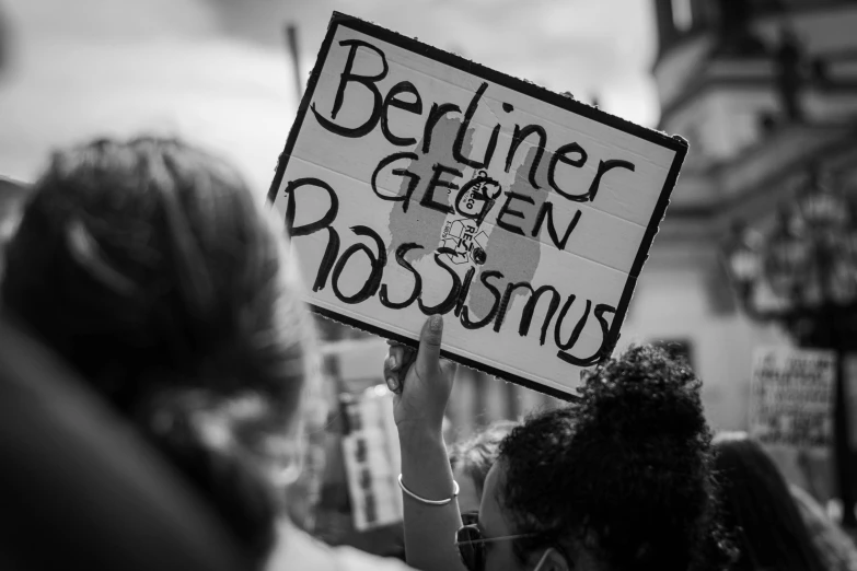 a person holding a sign that reads believe green crossing