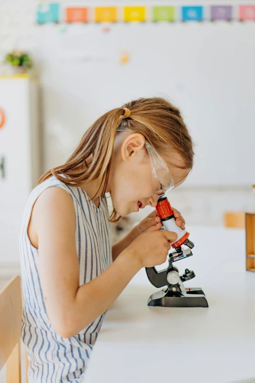 the child looks through the microscope to examine it