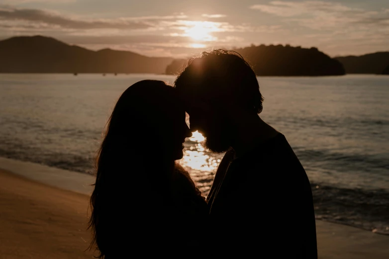 a couple is kissing each other in front of a lake