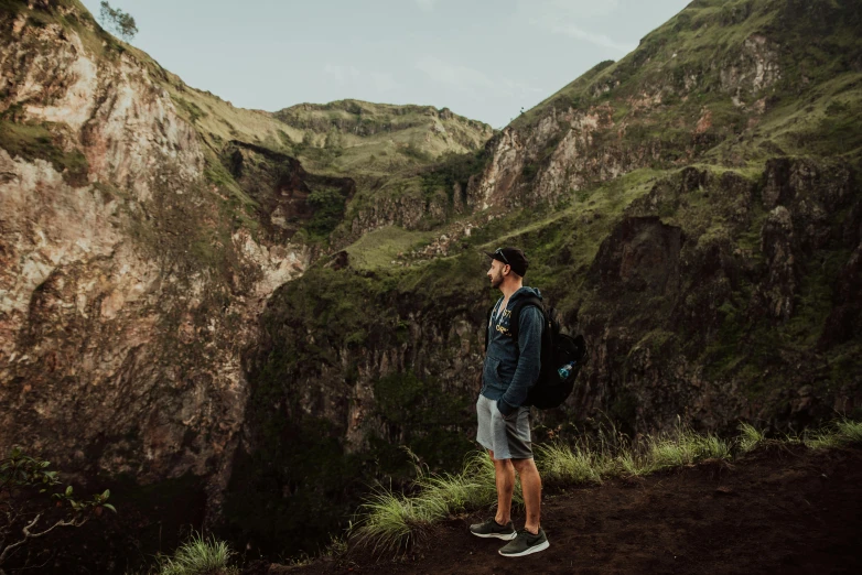 a man in blue jacket looking over mountains at mountains