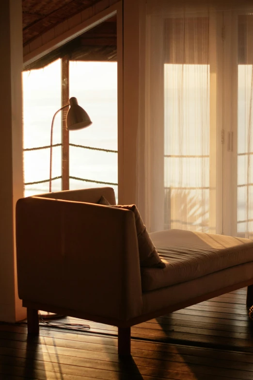 light pours in from an open window onto a chaise lounge