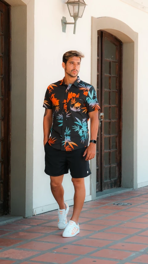 man in hawaiian shirt standing on street with tennis shoes