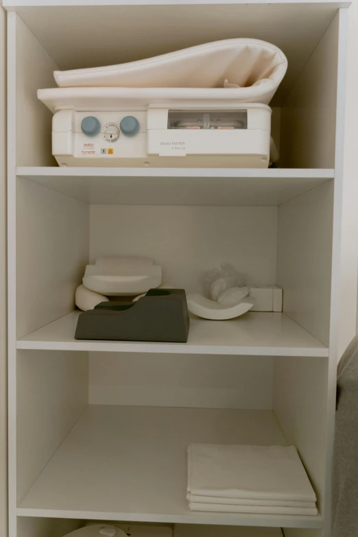 a closet with shelves that have books, a radio and some cloths on it