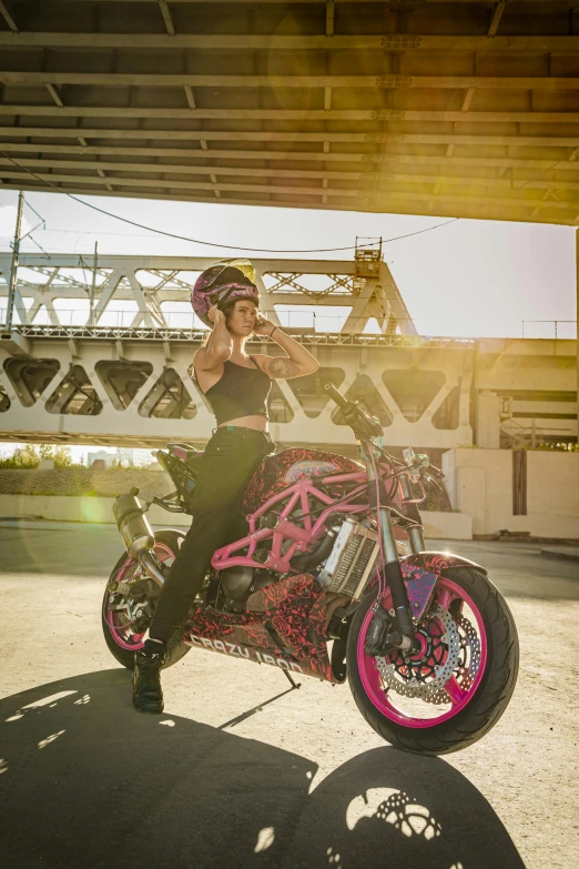 a woman is sitting on a pink motorcycle
