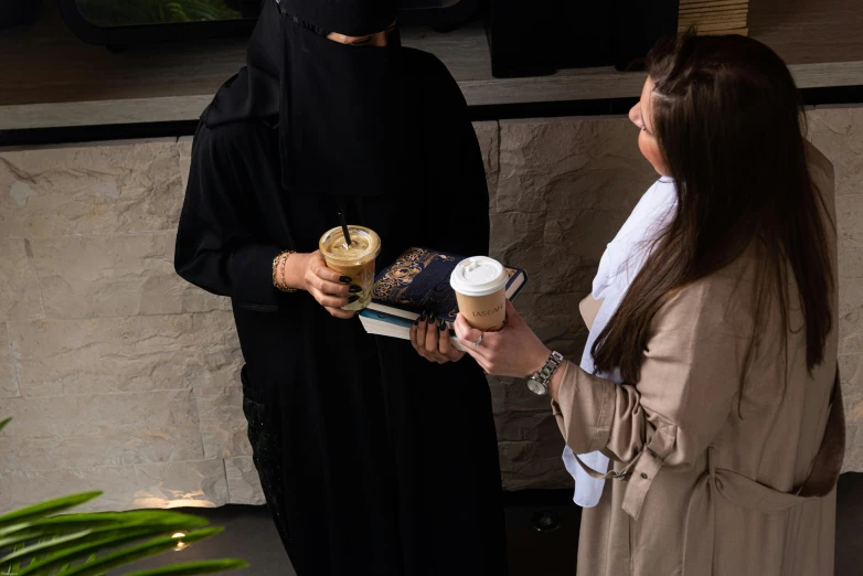 two women who are sharing a drink with each other