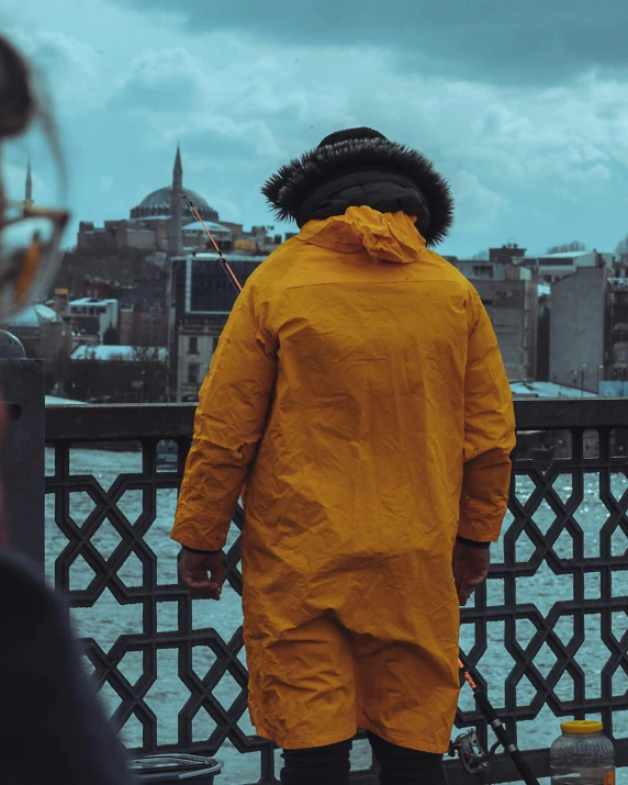 a person standing by the water wearing a yellow outfit