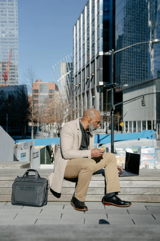 a man on the phone sits and looks at his cell phone