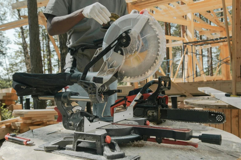 a person wearing gloves with a chainsaw