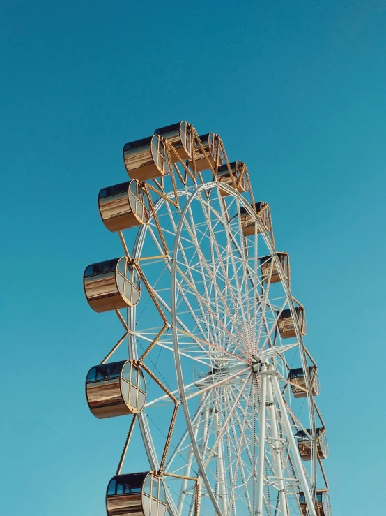 a ferris wheel against a blue sky with a jet engine