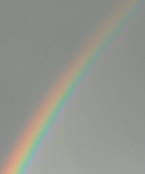 a plane flying in front of a rainbow