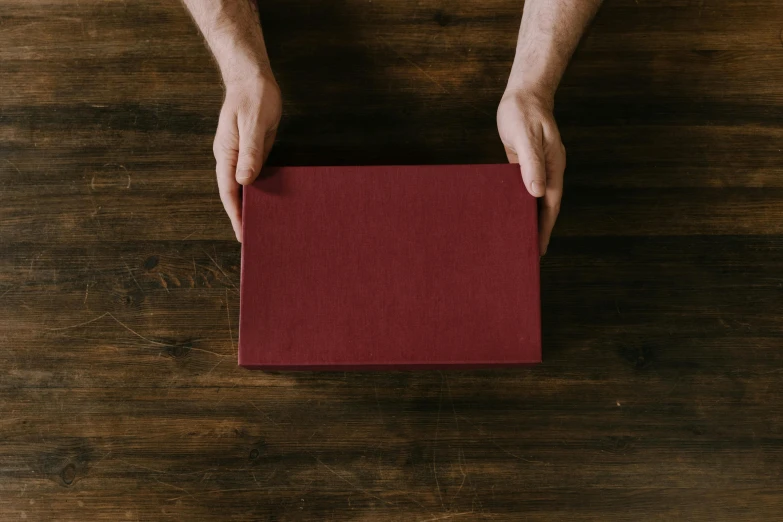 a person holds a red paper over their face