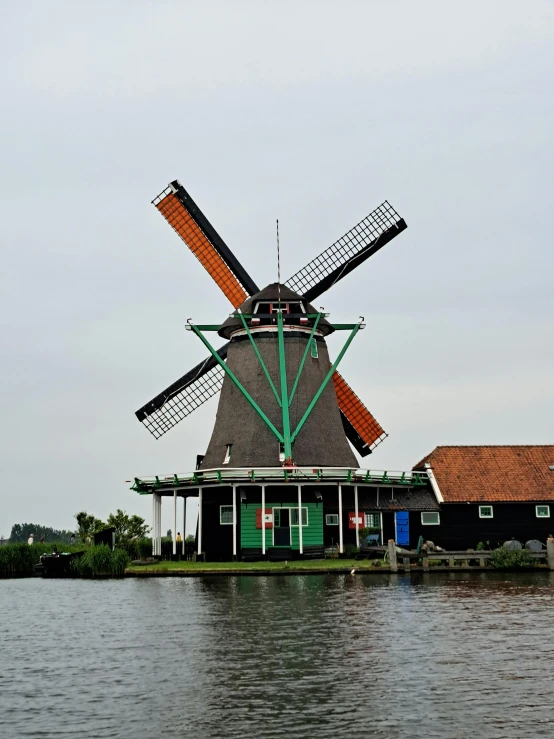 a windmill sits on top of a green building