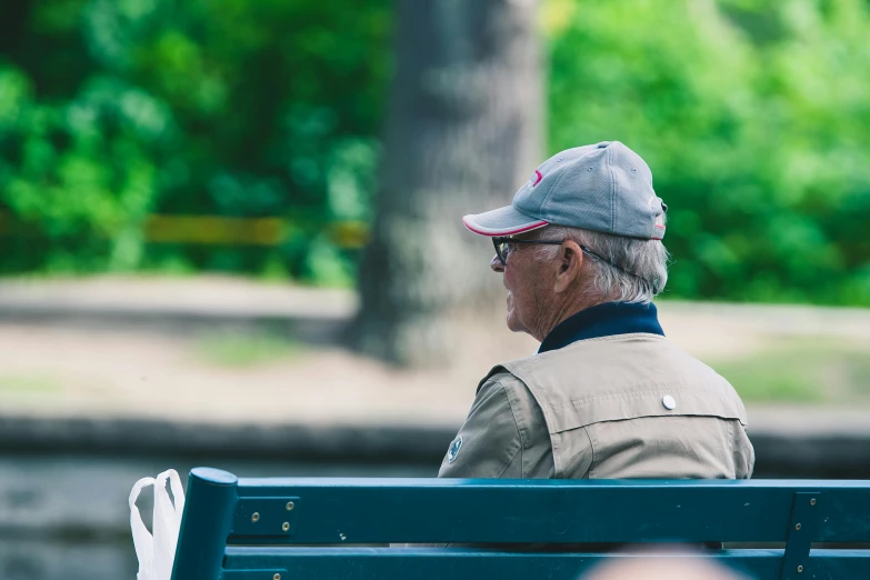 an older man sitting on a bench with his hands behind his back