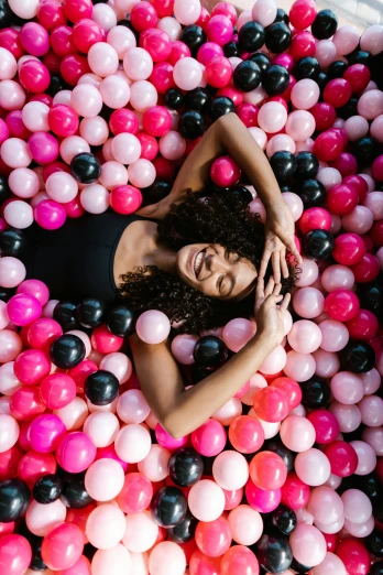 a  woman floating in a ball pit with her eyes closed