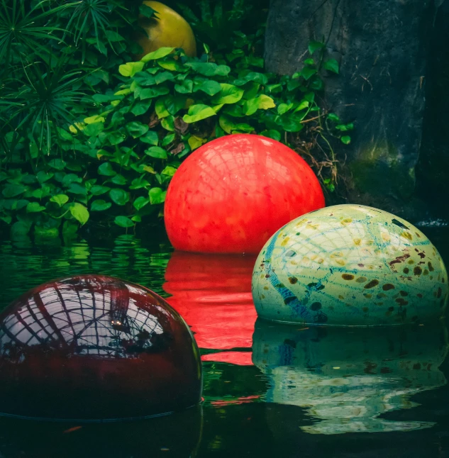 a group of balls floating on top of a body of water