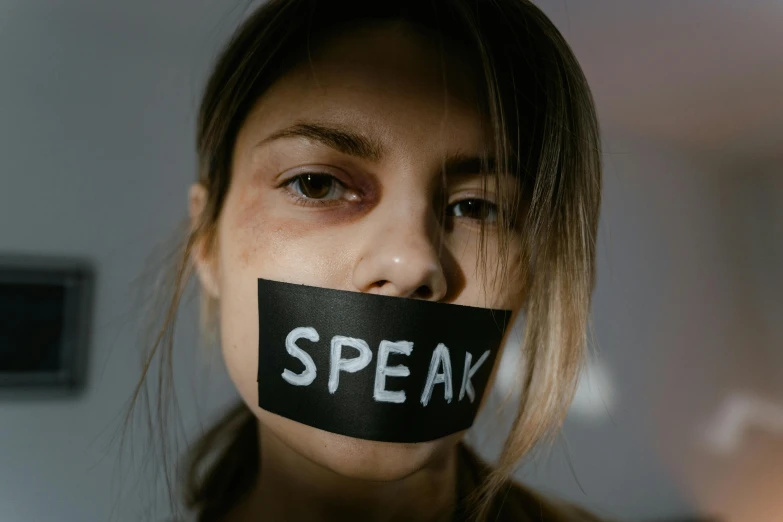  with tape over her mouth saying speak