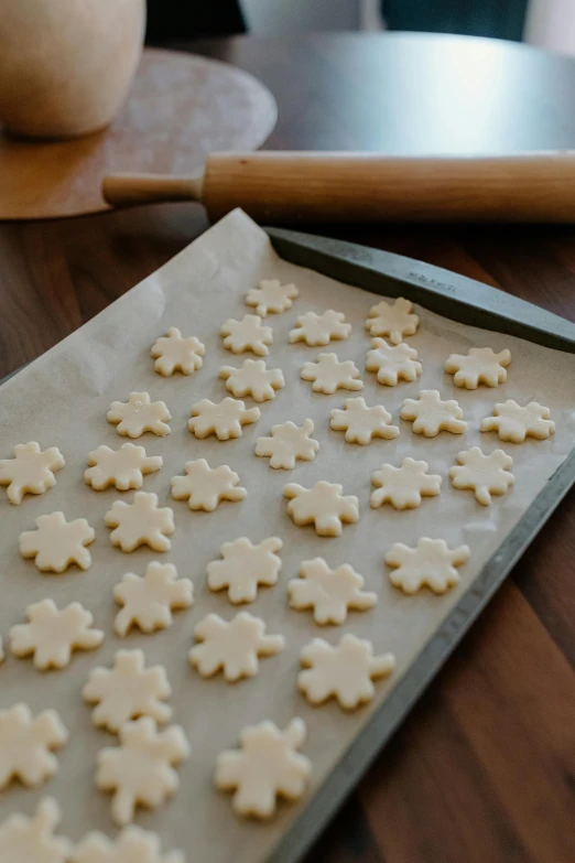 a sheet of cookie dough cut into snowflakes on a baking sheet