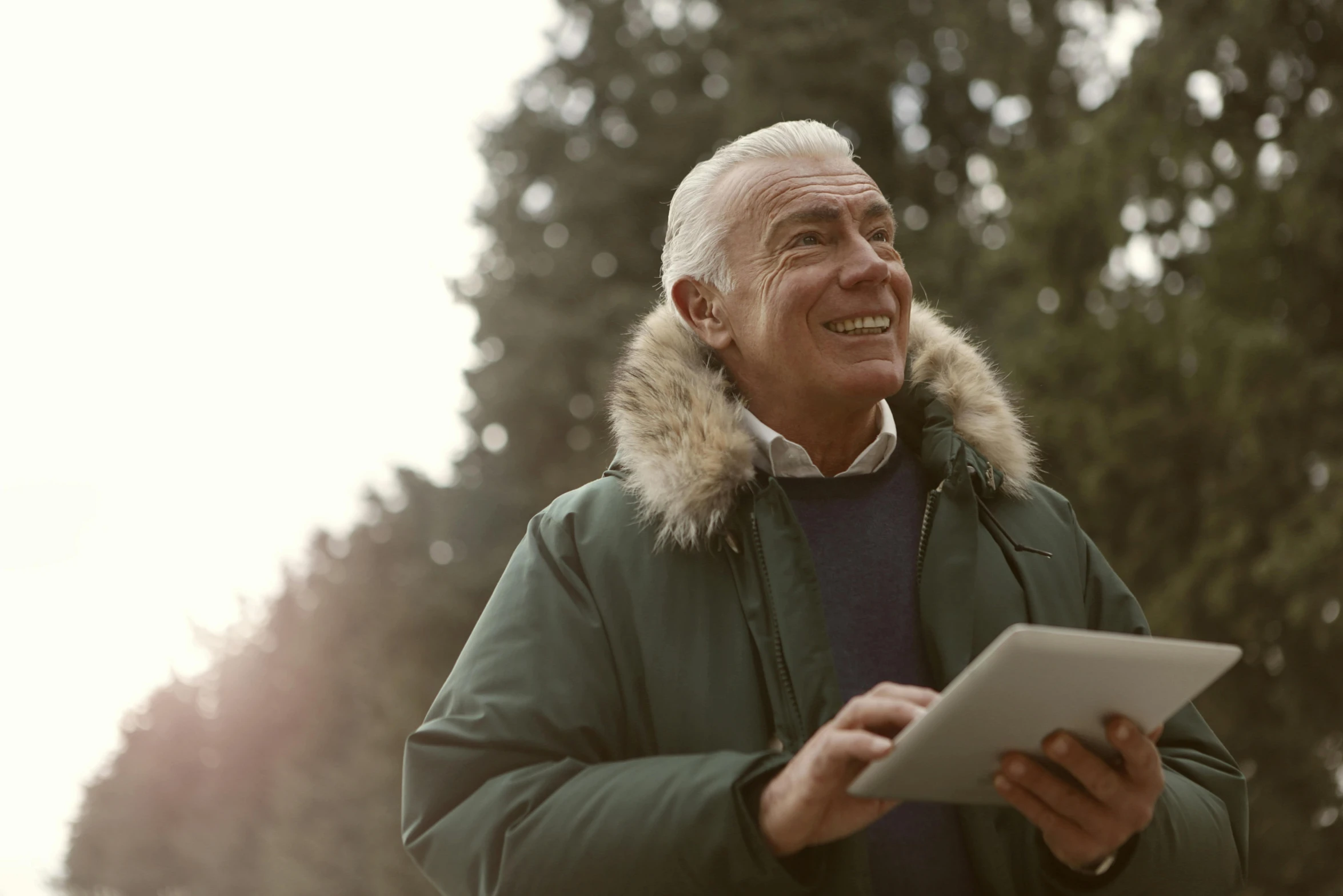 an older man uses his tablet while outside