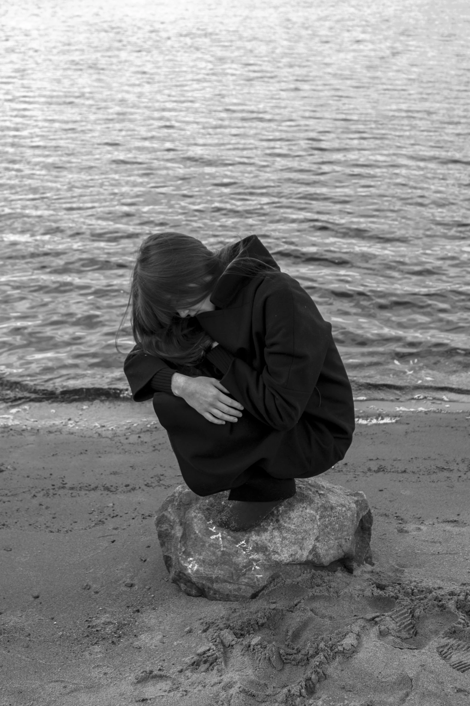 a woman who is sitting on a rock