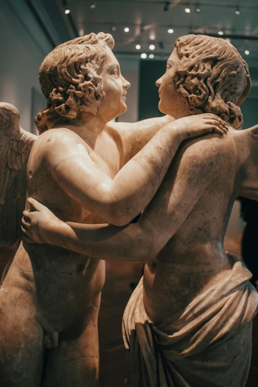 a couple of statues hugging each other in a room