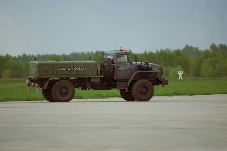 a green army truck is parked in a field