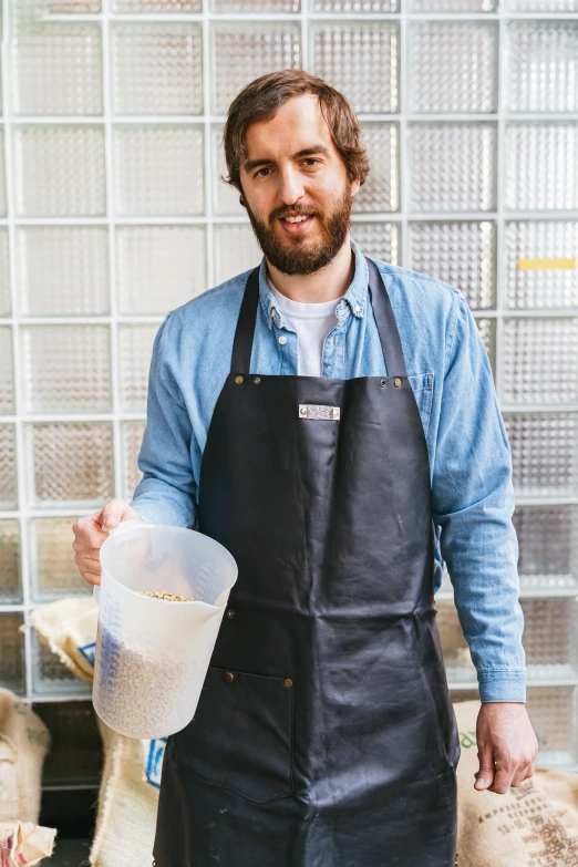 a man in an apron holding a container