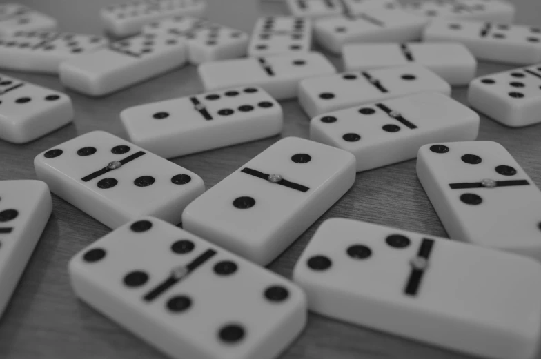 a close up of dominos on a table with a clock in the middle