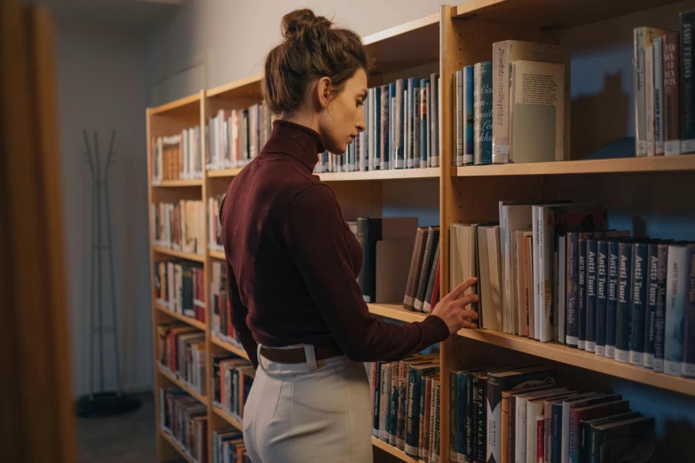 a person leaning up on a book shelf