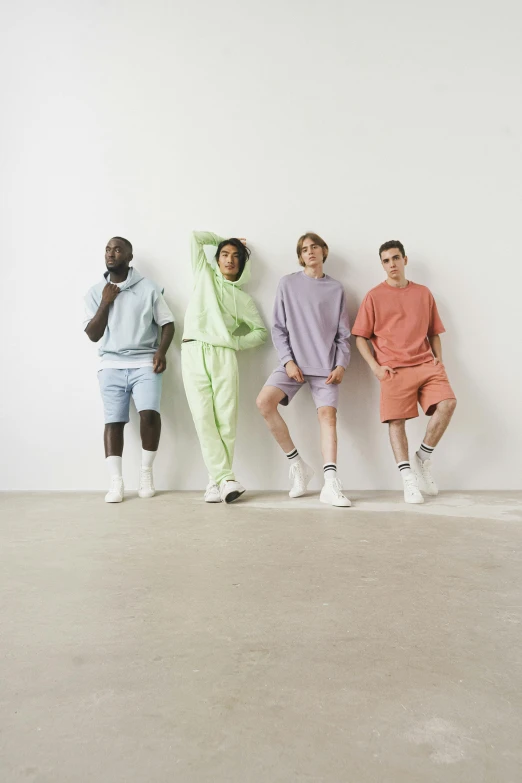 three guys are posed in different colors of the same outfit