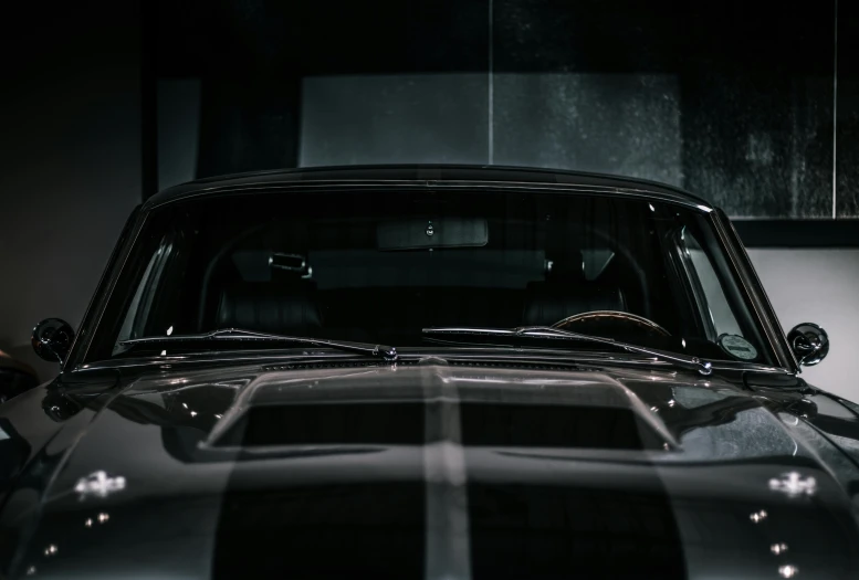 an old muscle car parked in a garage