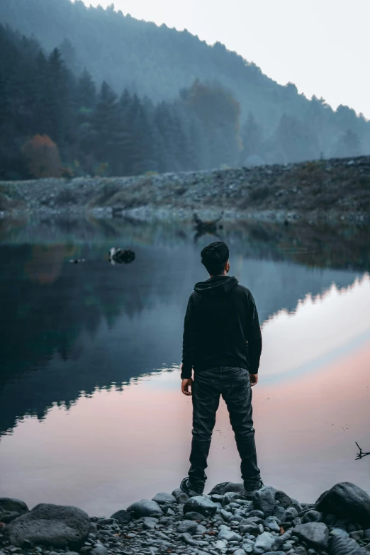 a person standing on a rock near water