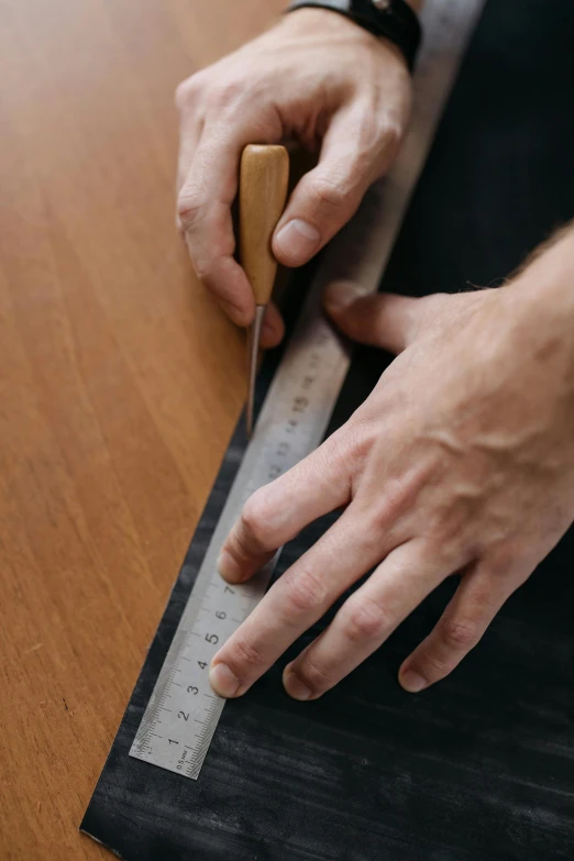 a person holding a wooden block and a measuring ruler