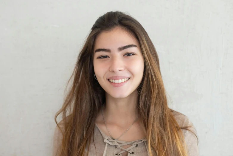 a woman is smiling with long brown hair