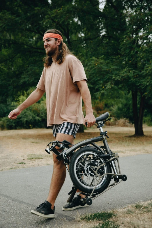 a man in plaid shorts standing next to a bike