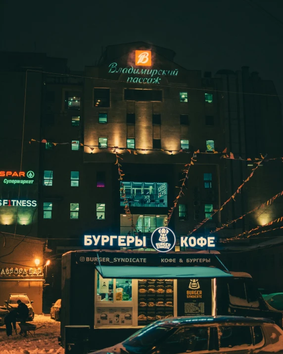 a bus drives past a building that is illuminated up with lights