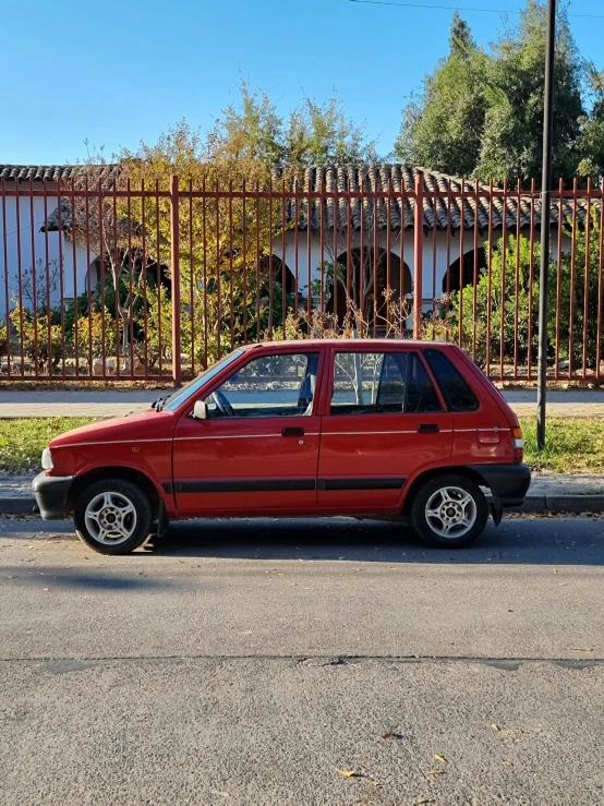 a car is parked on a street next to a fence