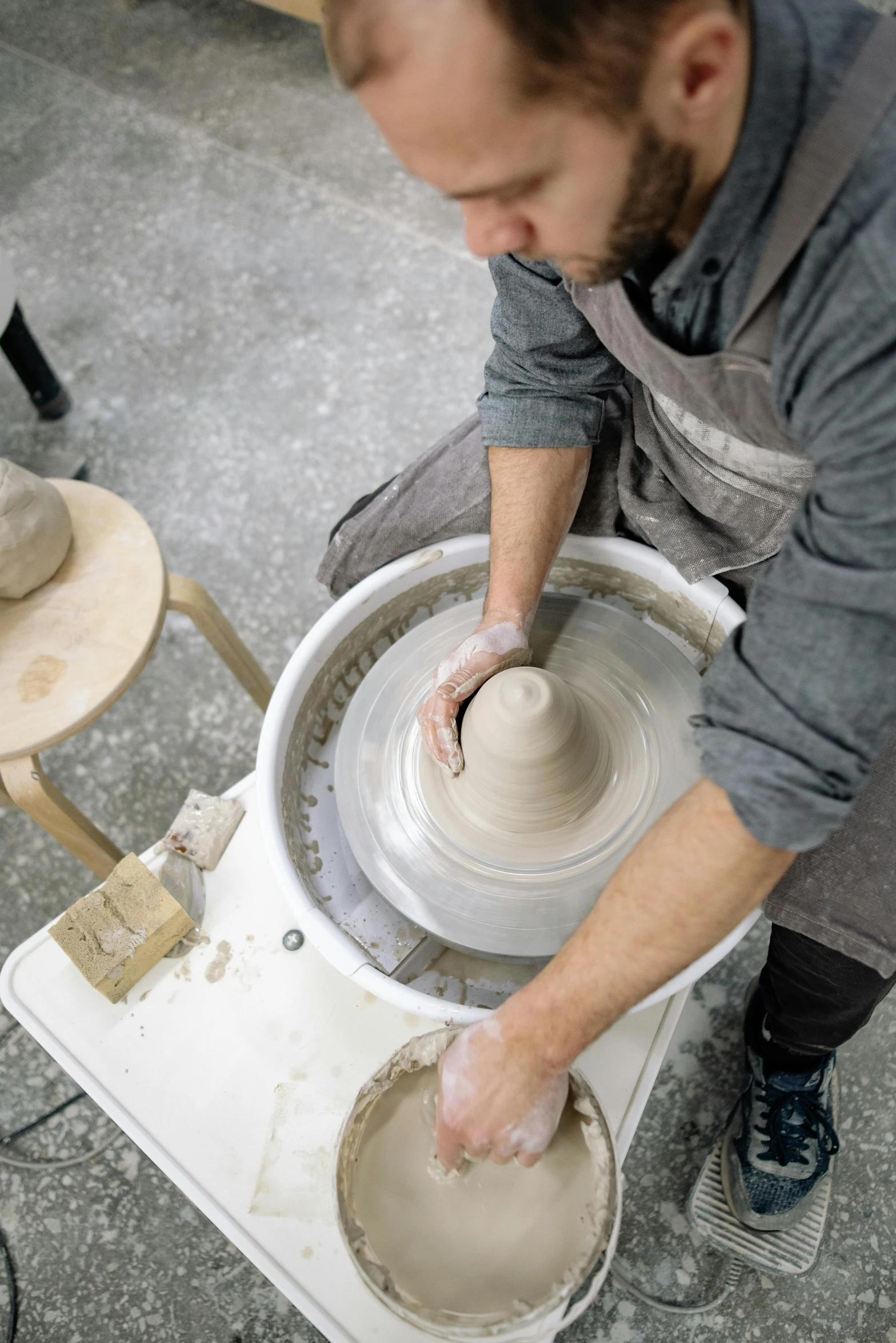 a man is making a vase on a spinning wheel