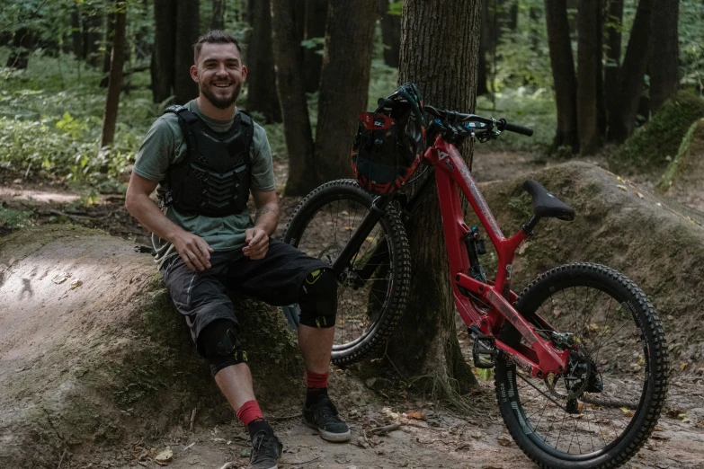 a man with a backpack and red bike