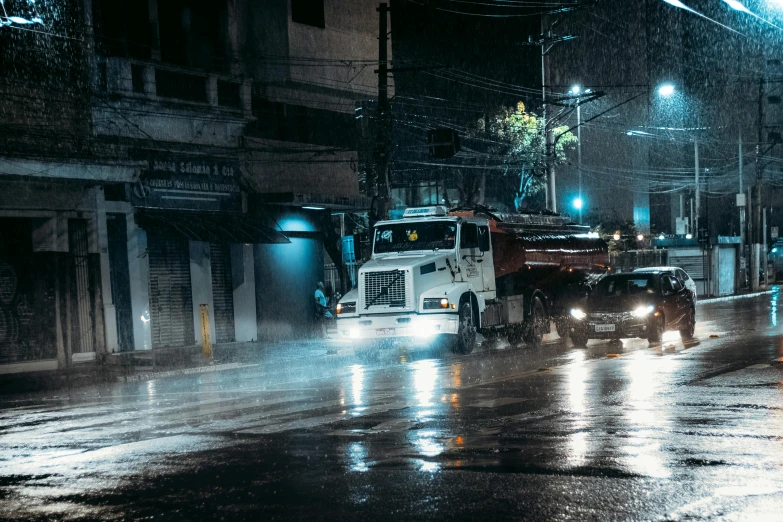 a couple of trucks driving down a street next to a building