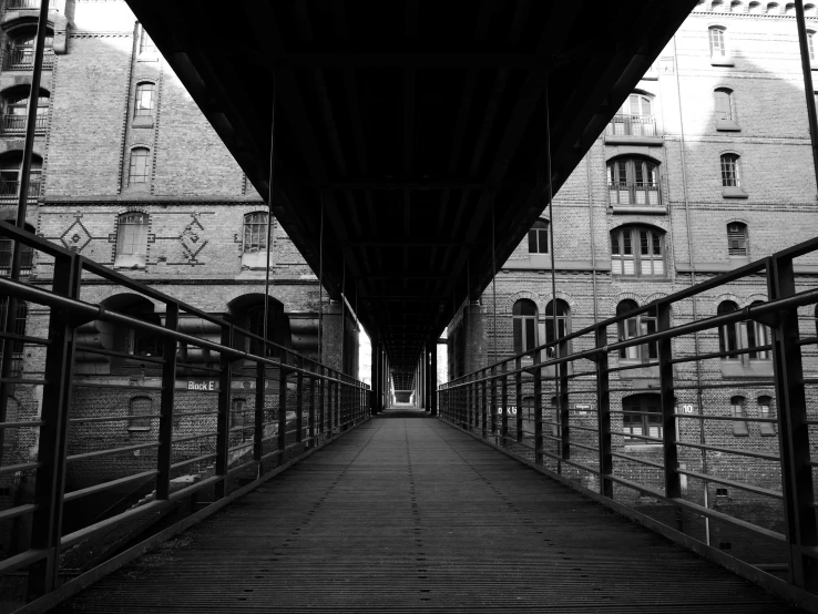 an empty walkway leading to buildings underneath it