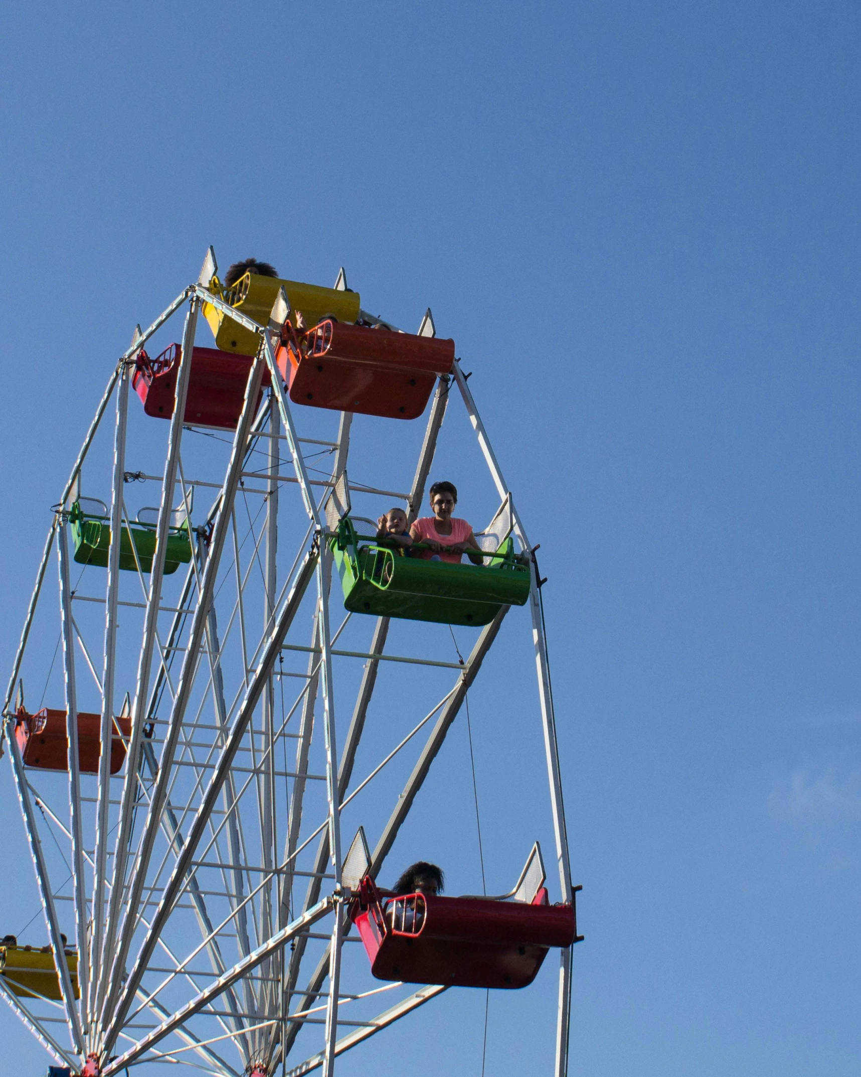 people ride on a ferris wheel at the carnival