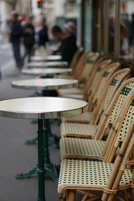 empty wicker table and chairs in the front of an outdoor cafe