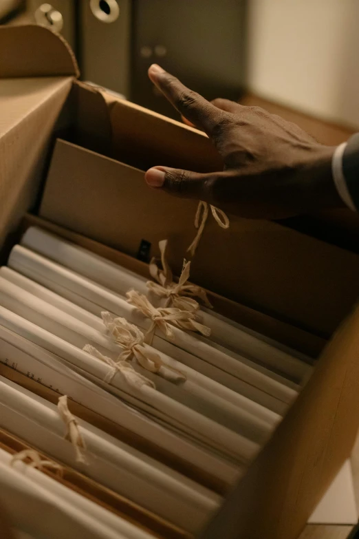 a person opens the cardboard box with their hands