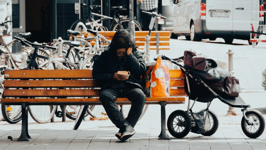 a woman is sitting on a bench while looking at her phone