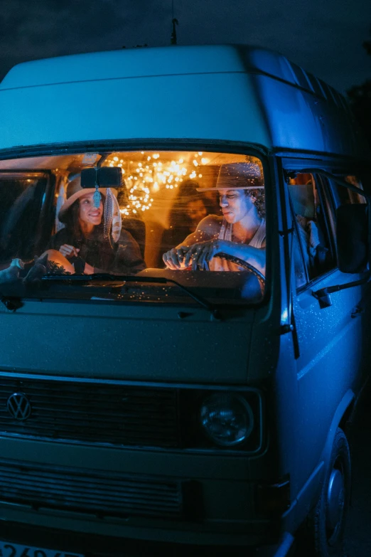 three women inside the van with some blue lights