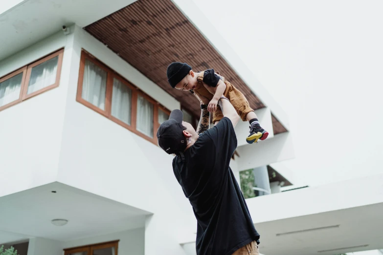 a man holds a small child while he reaches up